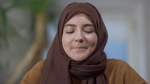 Nahaufnahme Porträt einer charmanten jungen Frau aus dem Nahen Osten im Hijab mit braunen Augen in die Kamera