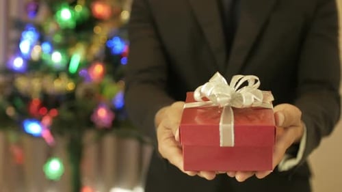 Man in Suit Holds Christmas Gift Box