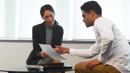 Professionals Discuss Documents in a Corporate Setting