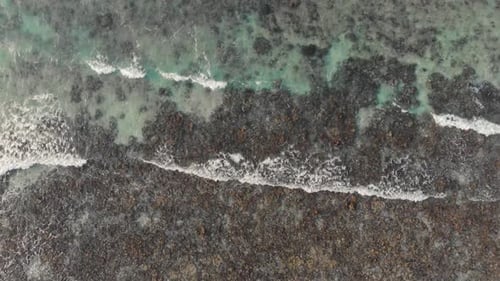 Aerial View of Waves Crashing on Rocky Shore