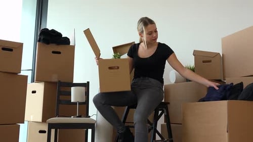 Woman Unpacking Boxes in New Apartment