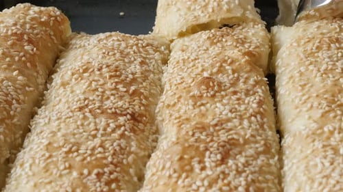 Arranging filo pie with sesame cheese and spinach close-up 4K 2160p 30fps UHD footage - Cutting bak