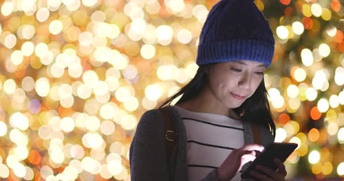 Woman use of smart phone over bokeh background