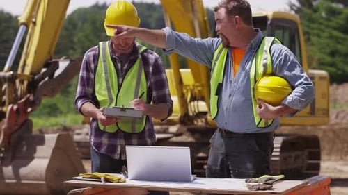 Construction workers looking at laptop computer
