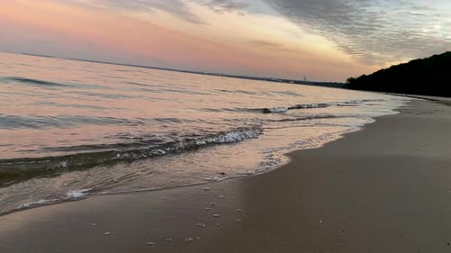 Gentle Waves on Sandy Beach at Sunset