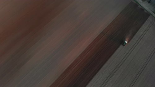 The tractor plows the brown, black soil. Spring sowing work in the field. Viernheim, Germany.