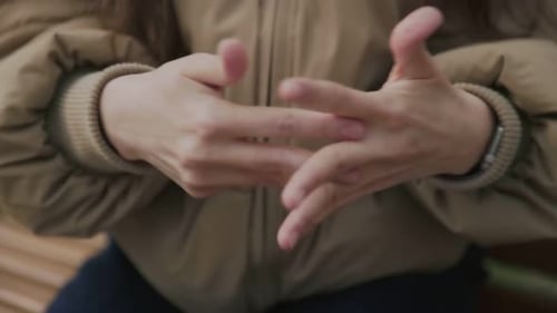 Woman Applies Hand Sanitizer on City Bench