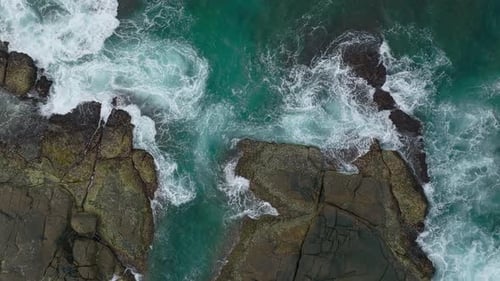 Waves Crash Against Rocks in the Ocean