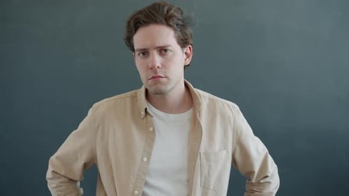 Man Glances Left in Front of Gray Background