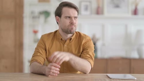 Pensive Young Man Thinking While Sitting in Office