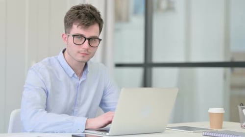 Man Working on Laptop in Bright Office