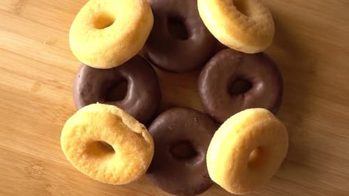 Assorted Glazed and Chocolate Donuts on Wooden Surface