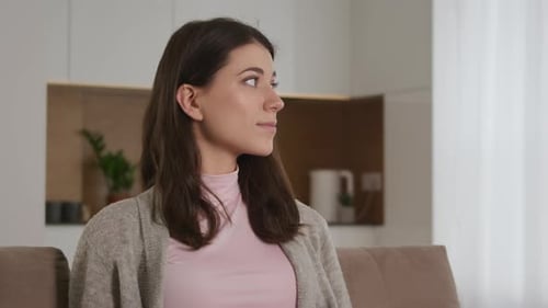Woman Smiling on Couch in Modern Home