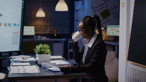 Femme d'affaires afro-américaine bourreau de travail analysant les statistiques marketing sur la paperasse