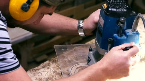 Male Carpenter Working with Milling Machine for Cutting Figure Wooden Detail