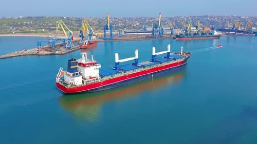 AERIAL VIEW: Flying Over Massive Ship Filled Moving in the Quiet Sea. Cargo Being Moved By Large