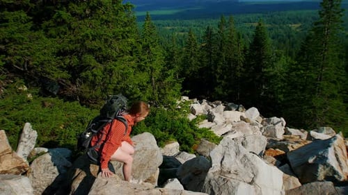 Young Woman Going Down the Mountain with Backpack on Her Back