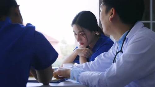 Doctors Collaborate Using Tablet Technology in Break Room