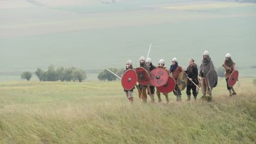 Medieval Warriors Charge Across Grassy Field with Shields