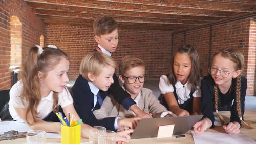 Children Collaborating on Laptop in Classroom
