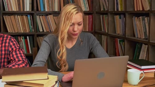 Fille blanche entourée de livres dans la bibliothèque