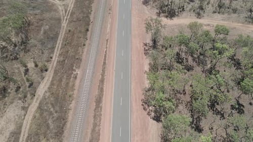 Drone shot of road with railway next to it moving to a river, Darwin, Northern Territory, Australia