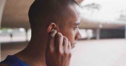 Side view man with prosthetic leg putting headphones
