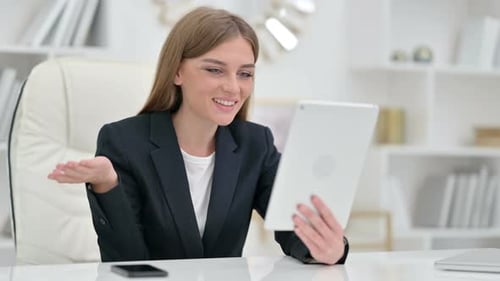 Woman Using Tablet For Video Call In Office