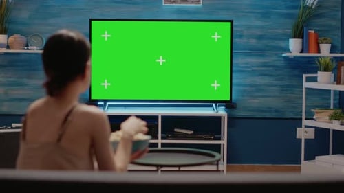 Femme regardant la télévision conçue avec un écran vert
