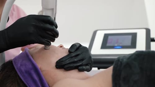 Woman Receiving Cosmetic Facial Treatment at Clinic