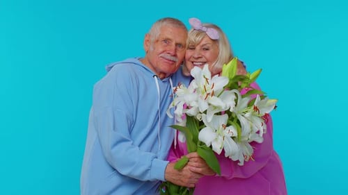 Senior Couple Celebrate Anniversary with Flowers and Hugs