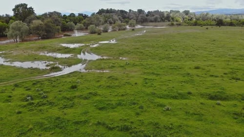 Vue aérienne des inondations d'une ferme rurale avec une maison de ferme sur des champs secs inondés