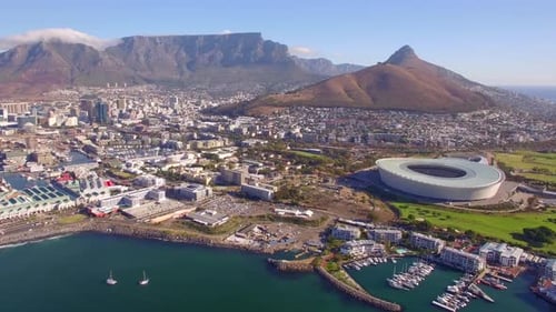 Aerial travel drone view of Cape Town, South Africa with Table Mountain and stadium.