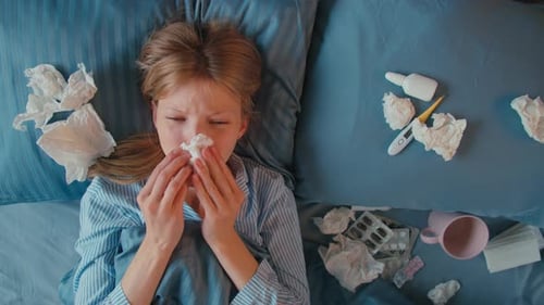 Woman With The Flu Lies Sick in Bed