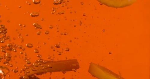 Lemon Slices and Ice Cubes Falling into Drink