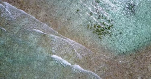 Wide birds eye clean view of a sandy white paradise beach and blue sea background in high resolution