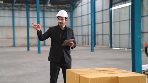 Factory Workers Deliver Boxes Package on a Pushing Trolley in the Warehouse