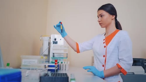 Woman Handling Blood Vial in Lab Setting