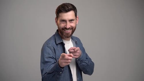 Hey du. Porträt eines glücklichen bärtigen Mannes, der vor hellgrauem Hintergrund posiert