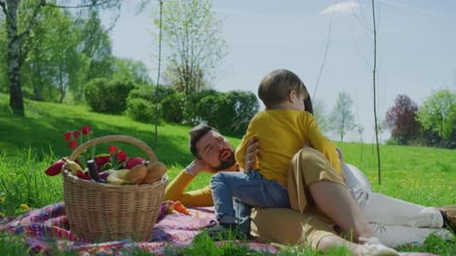 Loving Family Enjoying Picnic in Rural Grassy Field