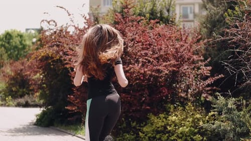 Woman Running in Park on Sunny Day