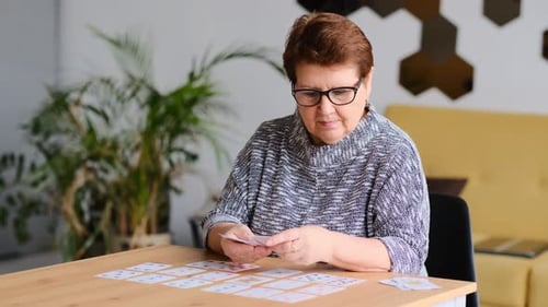 Femme âgée jouant au solitaire à la maison