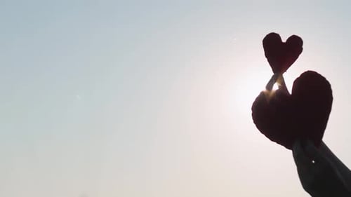 Hearts Held Up Towards the Bright Sun