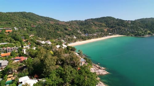 Empty white sand tropical beach surrounded by green mountains and clear turquoise water at Kata Beac