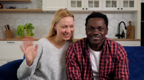 Happy Couple Waving and Smiling Indoors at Home