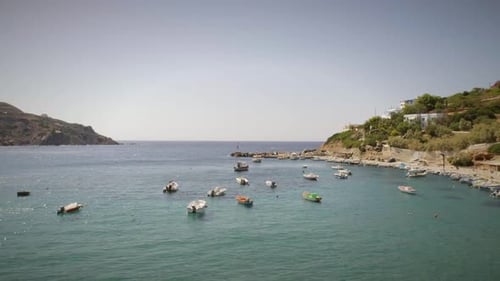 Aerial view of fishing boats anchored on the seashore in Greece.