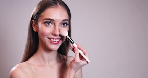 Woman Applying Makeup with Brush Close-Up