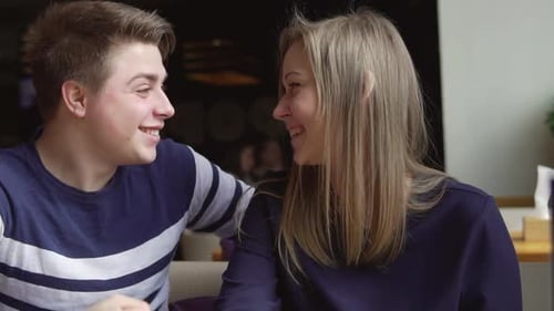 Young Attracrive Couple is Sitting at the Cafe Talking and Laughing