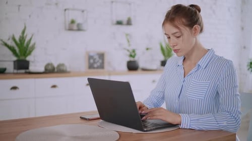 Woman Using Laptop in Bright Kitchen Home Office