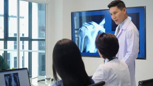 Medical Professionals Discussing X-Ray in Bright Conference Room